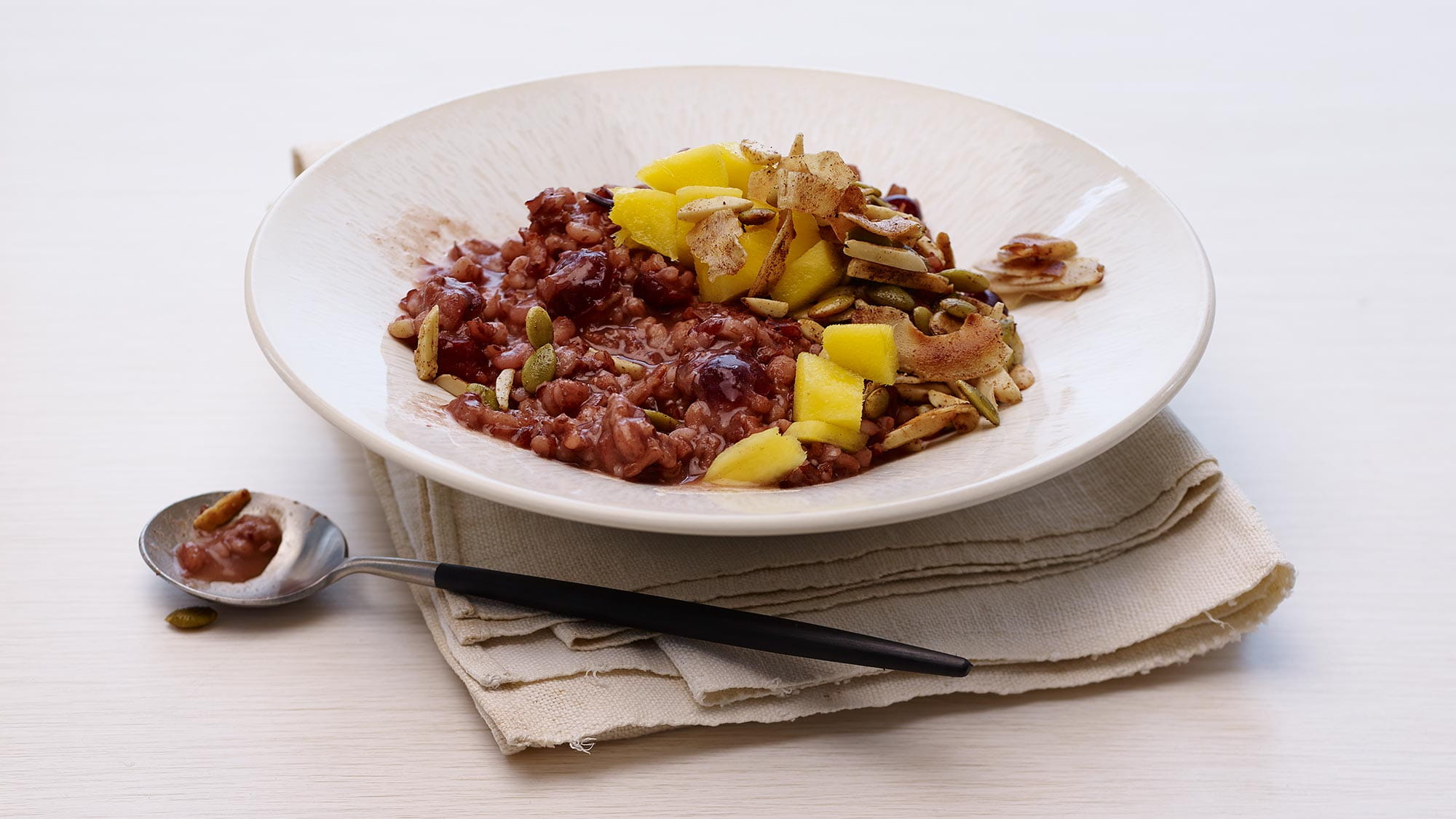 Roter Reis- und Gerstenbrei mit Mango und Kokosnuss