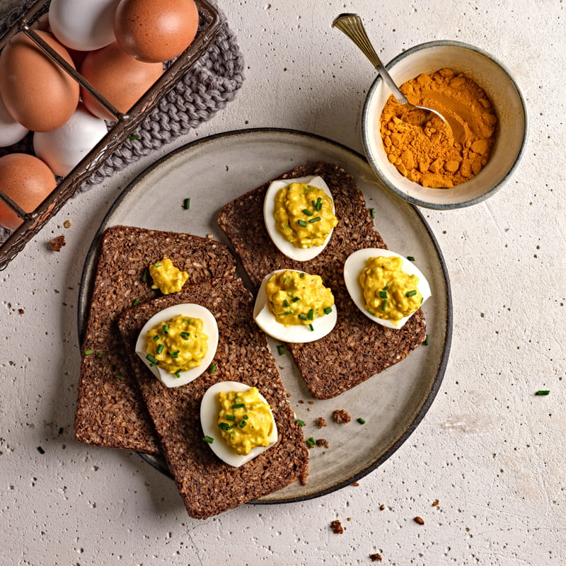 Oeufs garnis d’une farce au curcuma et pain pumpernickel
